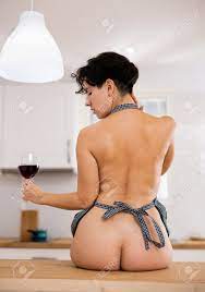 Portrait Of Luxurious Naked Woman In An Apron With Glass Of Red Wine In  Kitchen Stock Photo, Picture and Royalty Free Image. Image 198394738.