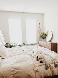 Neutral White Bedroom With Plants Wood Furniture And Lots Of Natural Light Plus A Cute Dog Bedroom Interior Home Decor Bedroom Stylish Bedroom