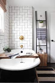 The white porcelain sink of this elegant and bright bathroom has pencil legs blending with the white flooring tiles trimmed with two rows of light gray tiles matching the gray patterned wallpaper accenting the white wooden finish of the walls. Before After A 125 Year Old Home Gets A Modern Makeover Domino Bathroom Design Bathroom Inspiration Bathroom Interior