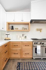 Bright white cabinets with wooden countertop, electric cooker, induction hob, faucet, sink and dish rack against. Golden Oak Cabinets Design Ideas