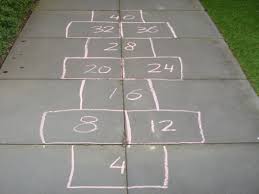 schrijf met stoepkrijt de antwoorden van een tafel in een hinkelbaan het spel werkt verder net als een gewone hinke tafels oefenen tafel leren spellingsregels