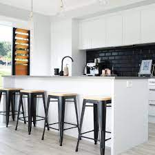 The full subway tile backsplash with dark grout in this kitchen clearly harks back to the early 1900s, yet the black quartz countertops bring it back to the modern style. 11 Ways To Beautifully Bring Black Subway Tile Into Your Home