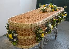 It shows a casket surrounded by beautiful flower arrangements. Blooming Chic Natural Funerals