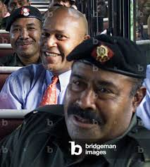 Image of Coup leader George Speight (2nd R) smiles as he sits