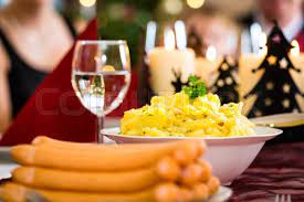 Photo about german mother, father, children celebrating christmas eve with traditional dinner wiener sausages and potato salad. Traditional German Christmas Eve Dinner Wiener Sausages And Potato Salad Stock Images Page Everypixel