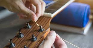 If the strings are broken, carefully place the guitar on a soft, flat surface to avoid damaging the guitar. How To Restring An Acoustic Guitar Easily Change Your Guitar Strings Today Music Industry How To