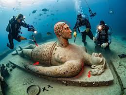 Off the rugged coast of Alexandria, deep under the waves, divers uncovered  what appears to be a submerged temple, an elaborate structure with a majestic  mermaid statue seated on a carved throne.
