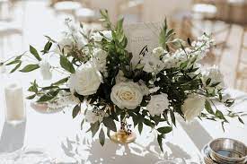 This decorative piece features budding and blooming white tulips sprouting up from thick leafy stems. A Classic Green White Coastal California Wedding Day Every Last Detail Flower Centerpieces Wedding Wedding Floral Centerpieces Wedding Centerpieces