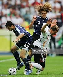 Sportspeople from germany in 2006. Lukas Podolski Of Germany Is Forced To The Ground Under Pressure From Javier Mascherano And Fabricio Coloccini Of Argen Argentina World Cup World Cup Argentina