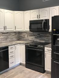 Backsplash For Black Countertops And White Cabinets Stackstone Backsplash Black Stainless Appliances White Cabinets Grey Granite Dona Concrete Countertops Kitchen Stone Backsplash Kitchen Kitchen Color White