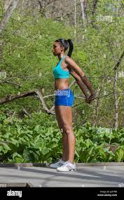 Fit pretty black girl in sports bra and shorts stretching in a wooded area  or forest Stock Photo - Alamy