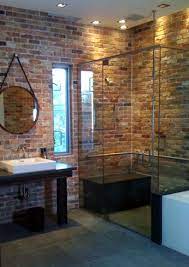 Browse remodelista posts on marble bathrooms to get ideas for your home remodeling or interiors project. A Contemporary Bathroom With Red Brick Walls A Glass Shower Space A Dark Vanity And A Large R Brick Bathroom Exposed Brick Bathroom Industrial Style Bathroom