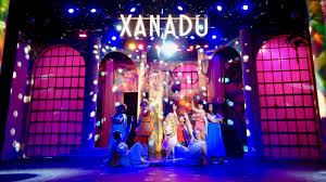 A show that dares to put feeble music, lyrics and jokes onstage does have therapeutic value — it helps an audience feel superior to it. Xanadu Glitters With Goofiness At The Garden Orlando Sentinel