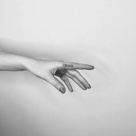 Create" lettering tattoo on the finger.