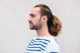 Close Up Side Portrait Of Young Man With Long Hair In Ponytail By White Background Stock Photo Picture And Royalty Free Image Image 136986537