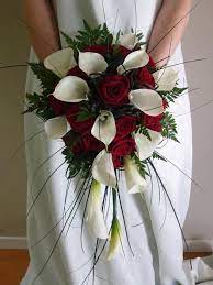 Known for their vibrance fragrance and versatility lilies are a popular choice for flower arra… Red Roses And Callalillys Bouquet Red Bouquet Wedding Wedding Flower Arrangements Teardrop Bouquet