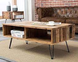 It's crafted from solid wood, with either an oak or walnut wood grain tone, and has a rounded surface set on four oval legs. Reclaimed Wood Coffee Table Wood Chevron Geometric Black Table Boho Decor Contemporary Art Deco Mid Century Modern Coffee Table Coffee Table Wood Coffee Table Design Coffee Table Rectangle