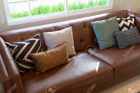 Sep 22, 2020 · the best living rooms, no matter how modern and minimal, have comfortable furniture, as shown in this lovely space by interior designer gi na kay daniel. Brown Leather Sofa With Graphic Pattern Pillow In Elegant Living Stock Photo Picture And Royalty Free Image Image 142425066