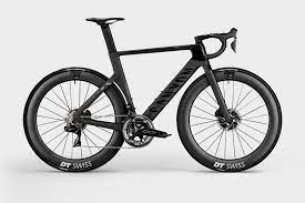 Mathieu van der poel voor de start van de derde rit, op zijn gele fiets, met op de achtergrond een foto van hem met zijn opa raymond poulidor. Dit Is De Nieuwe Canyon Aeroad Cfr Van Mathieu Van Der Poel Wielerflits