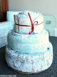 Assortment of baby accessories such as blankets, stuffed animals, bottles, pacifiers, etc. How To Make A Baby Shower Diaper Cake Viva Veltoro