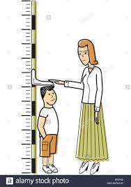 A Woman Measuring A Boy Against A Growth Chart Stock Photo