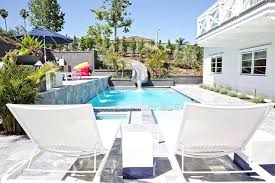 Modern White Pool Loungers With Black And White Cube Accent Chairs Alongside A Swimming Pool With A Curved Slide And A Pool Lounger Modern Pools Swimming Pools