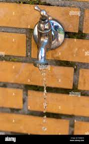 Leaking and water flowing outside water tap. Don't waste water its precious  Stock Photo - Alamy