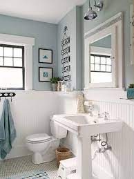 A vase of yellow flowers is selected to give a burst of color. Period Style Bathroom With White Painted Wainscoting And Light Blue Painted Upper Walls Tiled Floo Blue Bathroom Decor Gray Bathroom Decor Light Blue Bathroom