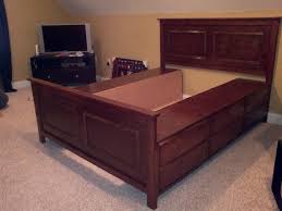 The full bed has a high headboard and sides with straight lines and carved details. The Bullock 5 Queen Platform Storage Bed Diy Diy Bed Storage Bed Diy Storage Bed