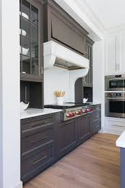 For example, if you are using 36 upper cabinets, your mounting height is 90. Dark Brown Range Hood With White Marble Corbels Transitional Kitchen