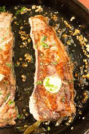 A Recipe For New York Strip Steaks Lightly Seasoned Then Pan Seared To Perfection Topped With A Homemade Garlic Strip Steak Recipe Steak Recipes Pan Recipes