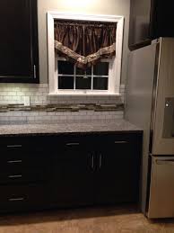 Maybe you would like to learn more about one of these? Kitchen Closeup New Caledonia Granite Escorial Blend And White Backsplash Tile Dark Brown Cabinets White Backsplash Brown Kitchen Cabinets Brown Kitchens