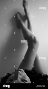sexy nackte Frau mit schwarze Federboa, liegend auf dem Bett, setzen ihre  Beine gegen die Wand Stockfotografie - Alamy