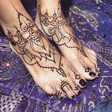 Henna Foot Tattoo Identical Designs In Brown Freshly Applied On A Pair Of Feet With Black Nail Polish Henna Tattoo Designs Foot Henna Henna Body Art