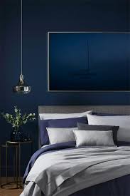 Navy blue headboard with navy blue pillows styled in a transitional bedroom beside a white nightstand featuring a baby blue urn lamp. 9 Fabulous Blue Bedroom Ideas That Will Inspire You To Decorate Inspiration Furniture And Choice
