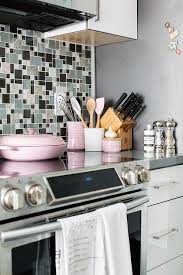 Dove grey and cream cabinets with brass handles and white subway tiles create an ethereal. Pink Kitchen Cookware Design Ideas