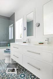 The toilet is discreetly hidden when you open the door, while the sink is at the opposite corner, in view of said door. White And Blue Mosaic Bath Floor Tiles Transitional Bathroom