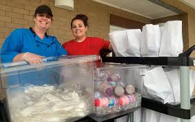 Cafeteria workers adjust for childrens' meals