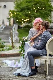 Woman with pink hair sits on man's knees at the dinner table on a ...