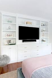 A Blue Velvet Upholstered Bed Faces A Built In Media Center Which Showcases Wall A In 2020 Bedroom Built Ins Master Bedroom Storage Ideas Bedroom Wall Units