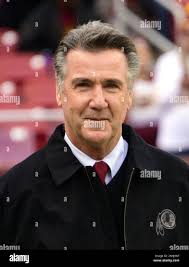 Washington Redskins team president Bruce Allen, far left, locks arms in  solidarity with players, from left to right, cornerback Kendall Fuller  (29), long snapper Nick Sundberg (57), cornerback Fabian Moreau (31), nose  tackle Ziggy Hood (90), defensive end ...