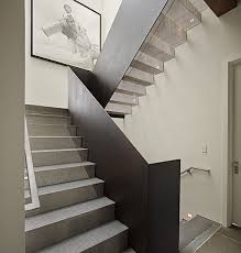 A sleek black lamp lights the adjacent stairwell, emphasizing the beautiful white stair railing and banister. Metal Stair Railing Design Ideas Pictures Remodel And Decor Staircase Design Modern Staircase House Stairs