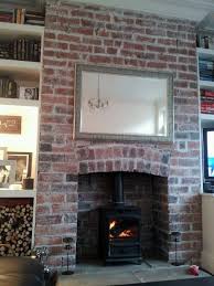 A wood fireplace mantel contrasts beautifully on this white brick fireplace! My Red Brick Fireplace Transformed Brick Fireplace Log Burner Red Brick Fireplaces Exposed Brick Fireplaces