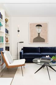 A minimalist living room with a refined black ceiling, a fireplace, some neutral furniture and yellow pillows. 25 Stunning Living Rooms With Blue Velvet Sofas Minimalist Living Room Decor Minimalist Living Room Minimalist Sofa