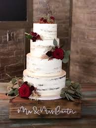 This Is A Barely Iced Four Tier Wedding Cake That Is Gorgeous In Front Of Wood And Bricks The R Wedding Cake Rustic Christmas Wedding Cakes Fall Wedding Cakes