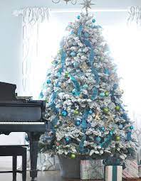 Play with fun color combinations like pink and blue, white and silver, or green and teal. White Flocked Tree Decorating Ideas Blue Gold Green Ornaments Ribbons Blue Christmas Tree Flocked Christmas Trees Teal Christmas Tree