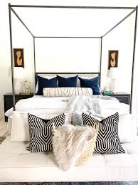 One of the biggest changes in this coastal master bedroom is the addition of a beautiful blue and tan quilt set. Coastal Master Bedroom Design With Walmart Home Frenchie In A Seagrass Basket In Front Of An Iron Canopy Bed Cc Mike