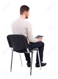 Sitting is a basic action and resting position in which the body weight is supported primarily by the bony ischial tuberosities with the buttocks in contact with the ground or a horizontal surface such as a chair seat, instead of by the lower limbs as in standing, squatting or kneeling. Back View Of Man Sitting On Chair And Looks At The Screen Of Stock Photo Picture And Royalty Free Image Image 61666713