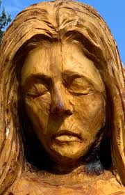 Chainsaw carver softens tree stump angel's face