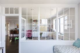 When thinking about the window design of a project, consider how windows integrate into the larger structure of the walls. A Wall Of Interior Windows Brings Light To This Guest Alcove Sweeten Com Interior Windows Living Room Kitchen Partition Glass Room
